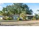 Charming single-story home featuring a well-maintained lawn and lush landscaping with mature trees and palms at 33801 Picciola Dr, Fruitland Park, FL 34731