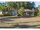 Charming single-story home featuring a well-maintained lawn and lush landscaping with mature trees and palms at 33801 Picciola Dr, Fruitland Park, FL 34731