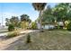 Home with a spacious front yard, mature landscaping, and a long driveway leading to the garage at 33801 Picciola Dr, Fruitland Park, FL 34731