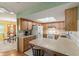 Kitchen with breakfast bar, wood cabinets, tile floors, and white appliances at 33801 Picciola Dr, Fruitland Park, FL 34731