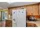 Kitchen features wood cabinets, granite countertops, and modern white appliances at 33801 Picciola Dr, Fruitland Park, FL 34731
