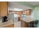 Kitchen featuring wood cabinets, breakfast bar, tile floors, and modern white appliances at 33801 Picciola Dr, Fruitland Park, FL 34731