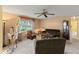 Comfortable living room featuring carpet flooring, neutral walls, a ceiling fan and lots of natural light at 33801 Picciola Dr, Fruitland Park, FL 34731