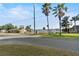 Scenic street view featuring palm trees, a glimpse of the water, and the home's charming neighborhood setting at 33801 Picciola Dr, Fruitland Park, FL 34731