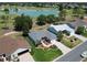 Aerial view of a well-maintained home with a brick driveway and beautifully landscaped front yard near a golf course and pond at 3614 Auburndale Ave, The Villages, FL 32162