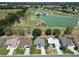 Scenic aerial view of homes situated near a lush golf course with a tranquil pond, showcasing the community's desirable location at 3614 Auburndale Ave, The Villages, FL 32162