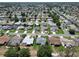 Expansive aerial view of a quiet neighborhood with tree-lined streets and well-maintained lawns adjacent to a golf course at 3614 Auburndale Ave, The Villages, FL 32162