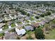 Expansive aerial view of a quiet neighborhood with tree-lined streets and well-maintained lawns adjacent to a golf course at 3614 Auburndale Ave, The Villages, FL 32162