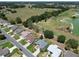 Aerial view of homes nestled near a golf course, boasting beautiful landscaping and proximity to green spaces and recreation at 3614 Auburndale Ave, The Villages, FL 32162