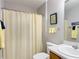 Clean bathroom with a striped shower curtain, and a mirror at 3614 Auburndale Ave, The Villages, FL 32162