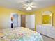Bright bedroom with floral bedding, white dresser, and doorway to closet and the bathroom at 3614 Auburndale Ave, The Villages, FL 32162