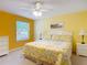 Bright bedroom with floral bedding, matching lamps, and dresser with a view to the window at 3614 Auburndale Ave, The Villages, FL 32162