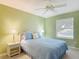 Bright bedroom with a ceiling fan, a window, and coordinated bedside lamps at 3614 Auburndale Ave, The Villages, FL 32162