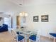 Dining area featuring a glass table, blue chairs and modern decor at 3614 Auburndale Ave, The Villages, FL 32162