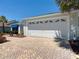 Spacious two-car garage featuring a brick-paved driveway and modern design at 3614 Auburndale Ave, The Villages, FL 32162