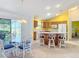 Bright modern kitchen and dining area with central island, bar stools, and sliding doors to the lanai at 3614 Auburndale Ave, The Villages, FL 32162