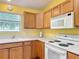 Kitchen area with wooden cabinets and white appliances at 3614 Auburndale Ave, The Villages, FL 32162