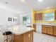 Spacious kitchen area featuring a large island, white appliances, and a yellow wall at 3614 Auburndale Ave, The Villages, FL 32162