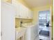 Convenient laundry room with washer, dryer, sink, and ample cabinet space at 3614 Auburndale Ave, The Villages, FL 32162