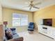 Cozy living room featuring neutral colored walls, comfortable seating, and a ceiling fan at 3614 Auburndale Ave, The Villages, FL 32162