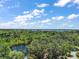 Scenic aerial perspective highlighting a tranquil pond nestled among mature trees, with a serene lake in the background at 3630 Oak St, Mount Dora, FL 32757