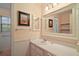 Charming bathroom featuring a vanity with framed mirrors, wainscoting, and natural light, creating a serene atmosphere at 3630 Oak St, Mount Dora, FL 32757