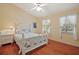 Sunny bedroom with a white bed frame, light walls, wood floors, and two bright windows providing a cheerful atmosphere at 3630 Oak St, Mount Dora, FL 32757