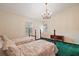 Cozy bedroom featuring two beds, a decorative chandelier, and ample natural light for a comfortable and inviting atmosphere at 3630 Oak St, Mount Dora, FL 32757