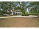 Long circular driveway leads up to the charming two-story home surrounded by lush, mature trees at 3630 Oak St, Mount Dora, FL 32757