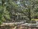 Two-story home featuring lush trees, shutters, a brick walkway, and manicured landscaping at 3630 Oak St, Mount Dora, FL 32757
