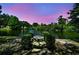Scenic exterior view with a pond and table in a well-manicured backyard oasis at 3630 Oak St, Mount Dora, FL 32757