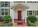Welcoming front door of home with a brick pathway, covered entrance, and mature shrubs at 3630 Oak St, Mount Dora, FL 32757