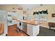 Functional kitchen with an island, white cabinetry, views to the outside, and hardwood floors at 3630 Oak St, Mount Dora, FL 32757