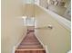 Carpeted staircase featuring painted walls, and a sturdy handrail, providing a safe and stylish transition between floors at 3630 Oak St, Mount Dora, FL 32757