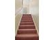 Carpeted stairs leading to the second floor, bathed in natural light from an unseen window at 3630 Oak St, Mount Dora, FL 32757