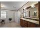Bathroom featuring double sinks, framed mirrors, and a tiled floor at 37945 Monticello St, Leesburg, FL 34788