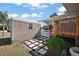 Home exterior with shed, landscaped yard, and wooden porch and stairs at 37945 Monticello St, Leesburg, FL 34788