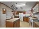 Cozy kitchen featuring wood cabinets, center island, tile countertops, and a hanging pot rack at 37945 Monticello St, Leesburg, FL 34788