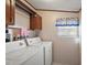 Functional laundry room featuring a washer, dryer, and overhead storage cabinets at 37945 Monticello St, Leesburg, FL 34788