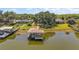 Aerial shot of the dock extending into the tranquil lake, surrounded by lush greenery at 38420 Langlois Pl, Leesburg, FL 34788