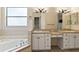 Bathroom featuring a tub, dual sinks, vanity area, and lots of vanity storage at 38420 Langlois Pl, Leesburg, FL 34788