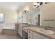 Bright bathroom features dual sinks, a large mirror, and a glass-enclosed shower at 38420 Langlois Pl, Leesburg, FL 34788