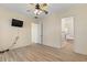 Bedroom with a ceiling fan, wood-look floors, and an entrance to the bathroom at 38420 Langlois Pl, Leesburg, FL 34788