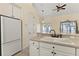 Bright kitchen with island, white cabinetry, breakfast bar and stainless steel sink at 38420 Langlois Pl, Leesburg, FL 34788