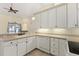 Open kitchen with white cabinets, countertops, stainless steel appliances and tile flooring at 38420 Langlois Pl, Leesburg, FL 34788