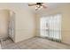 Neutral living room featuring large window, neutral walls, ceiling fan, and tile flooring at 38420 Langlois Pl, Leesburg, FL 34788