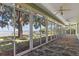 Screened-in patio offering panoramic lake views with ceiling fans and tiled flooring for outdoor relaxation at 38420 Langlois Pl, Leesburg, FL 34788