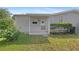 Back porch area showcasing an entrance framed by greenery and outdoor space at 432 King Way, Tavares, FL 32778