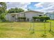 Fenced backyard featuring a well-maintained lawn, garden beds, and a view of the home's rear exterior at 432 King Way, Tavares, FL 32778