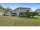 Landscaped backyard with manicured hedges and a well-maintained lawn, showing the home's exterior at 432 King Way, Tavares, FL 32778